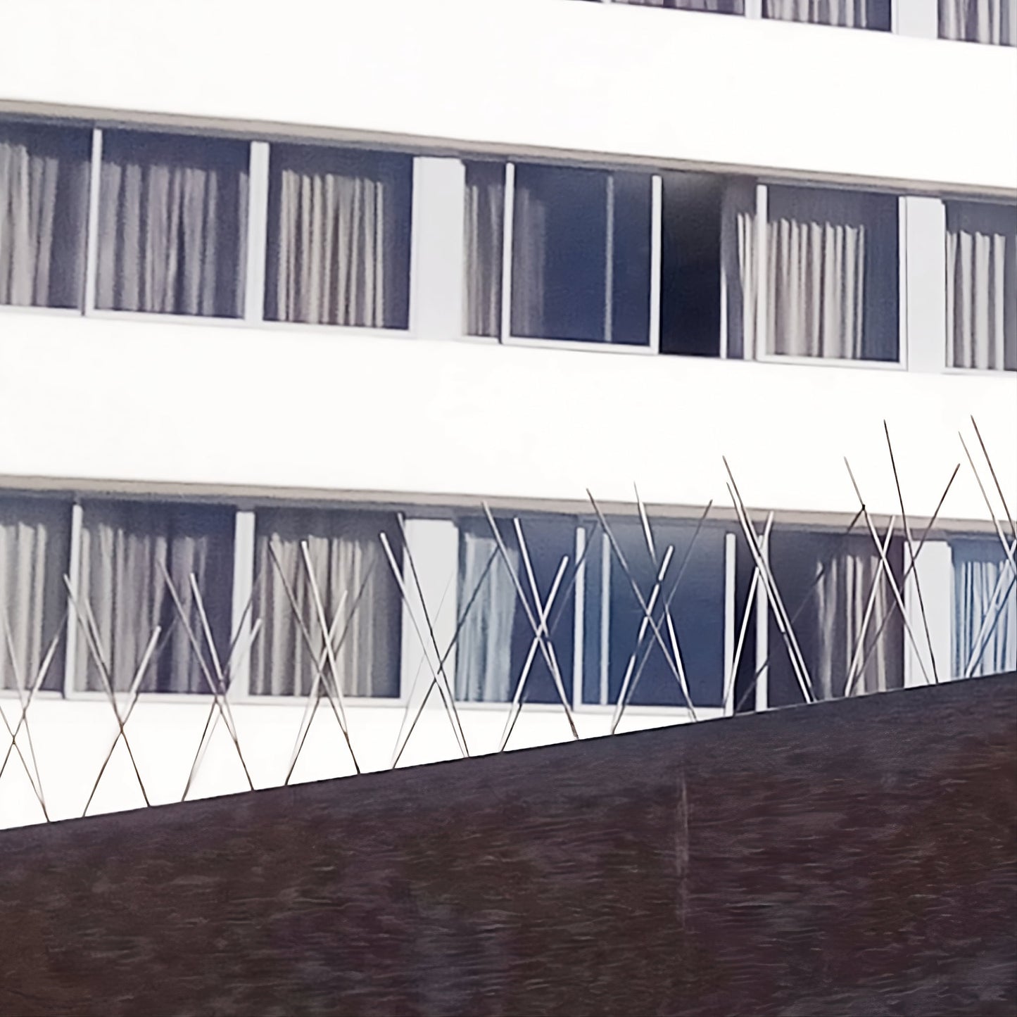 Stainless steel bird proofing spikes installed on a hotel exterior for effective commercial bird control.