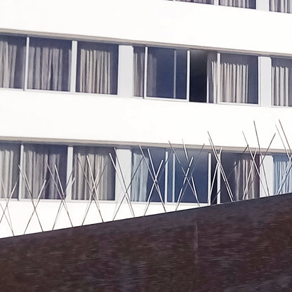 Stainless steel bird proofing spikes installed on a hotel exterior for effective commercial bird control.